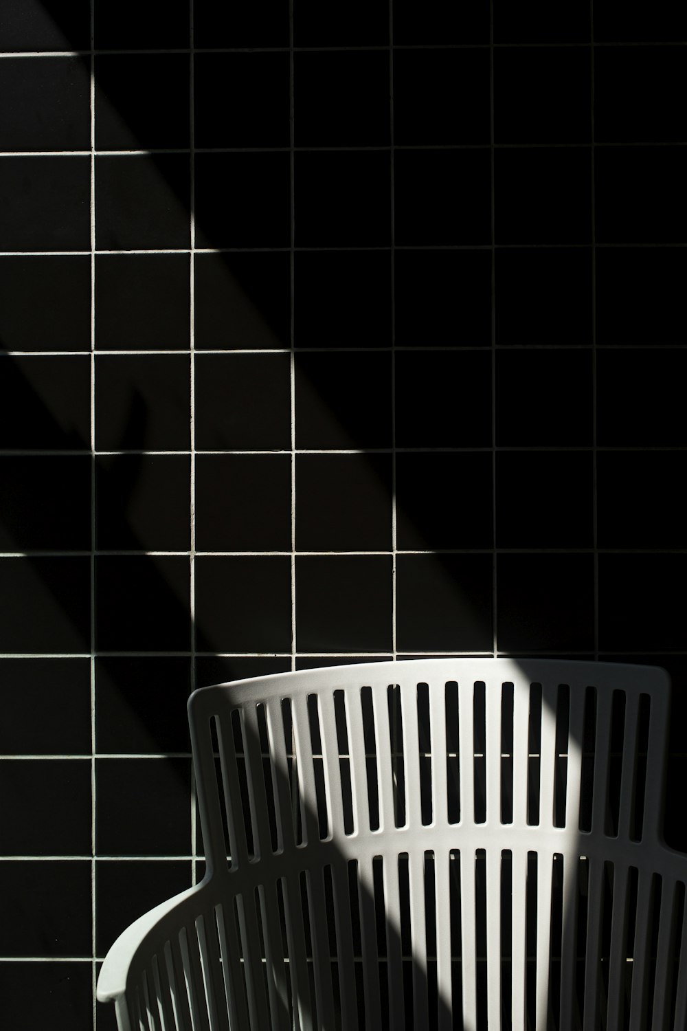 white plastic laundry basket on black floor tiles
