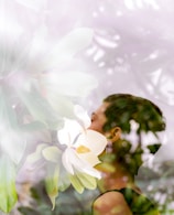woman standing near white flowers, receiving personal healing
