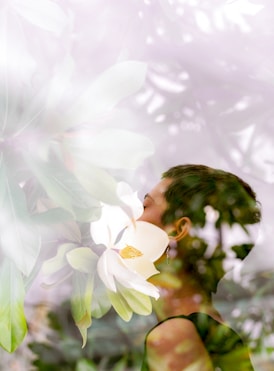 woman standing near white flowers, receiving personal healing