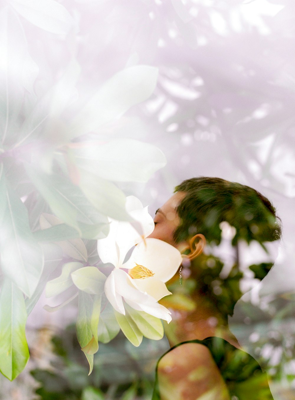 Frau im weißen Hemd steht neben weißen Blumen