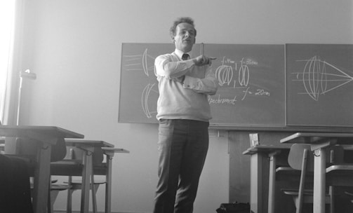 man in gray crew neck t-shirt and black pants standing near black wooden table