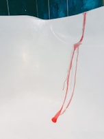 A hand safely applying the stain remover on a delicate kitchen tile.