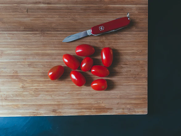 A sleek set of six non-stick knives arranged neatly on a wooden cutting board.