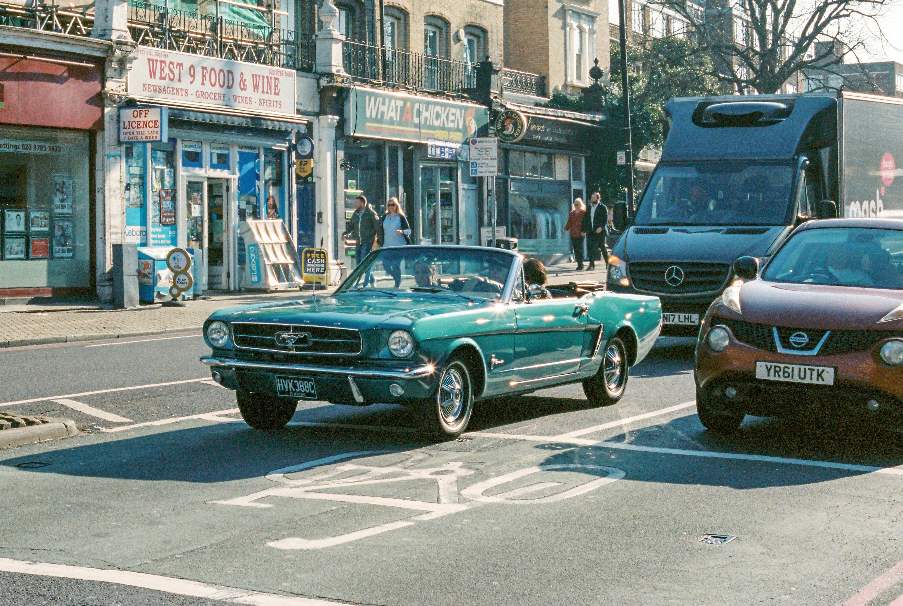 teal classic car on road during daytime