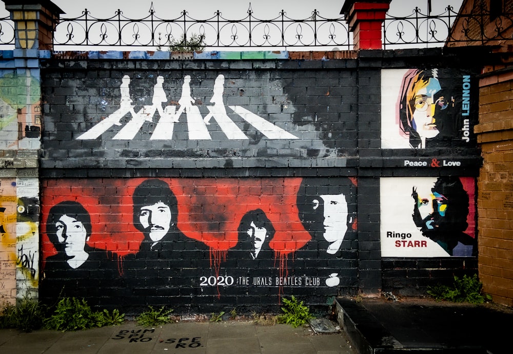 graffiti rossi, bianchi e neri su recinzione metallica grigia