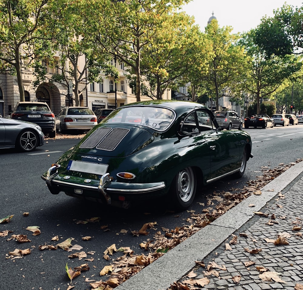 green porsche 911 parked on sidewalk during daytime