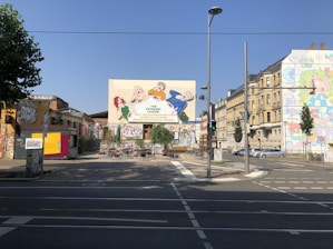 A scenic street view showcasing colorful murals and bustling cafes in an urban neighborhood.