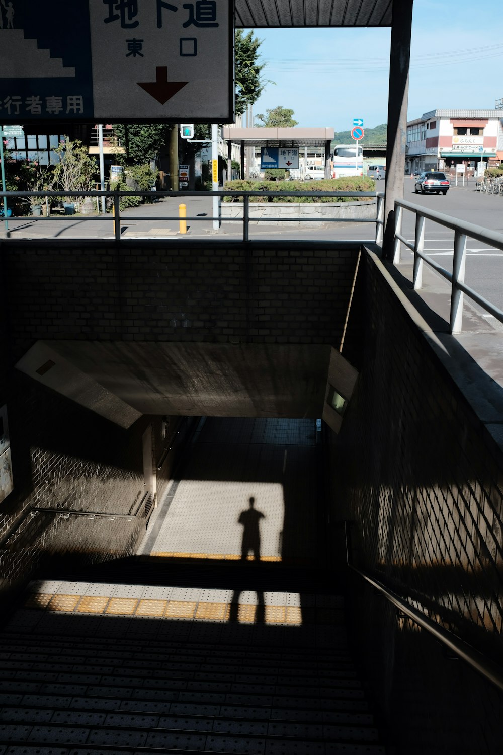 person in black shirt walking on sidewalk during daytime