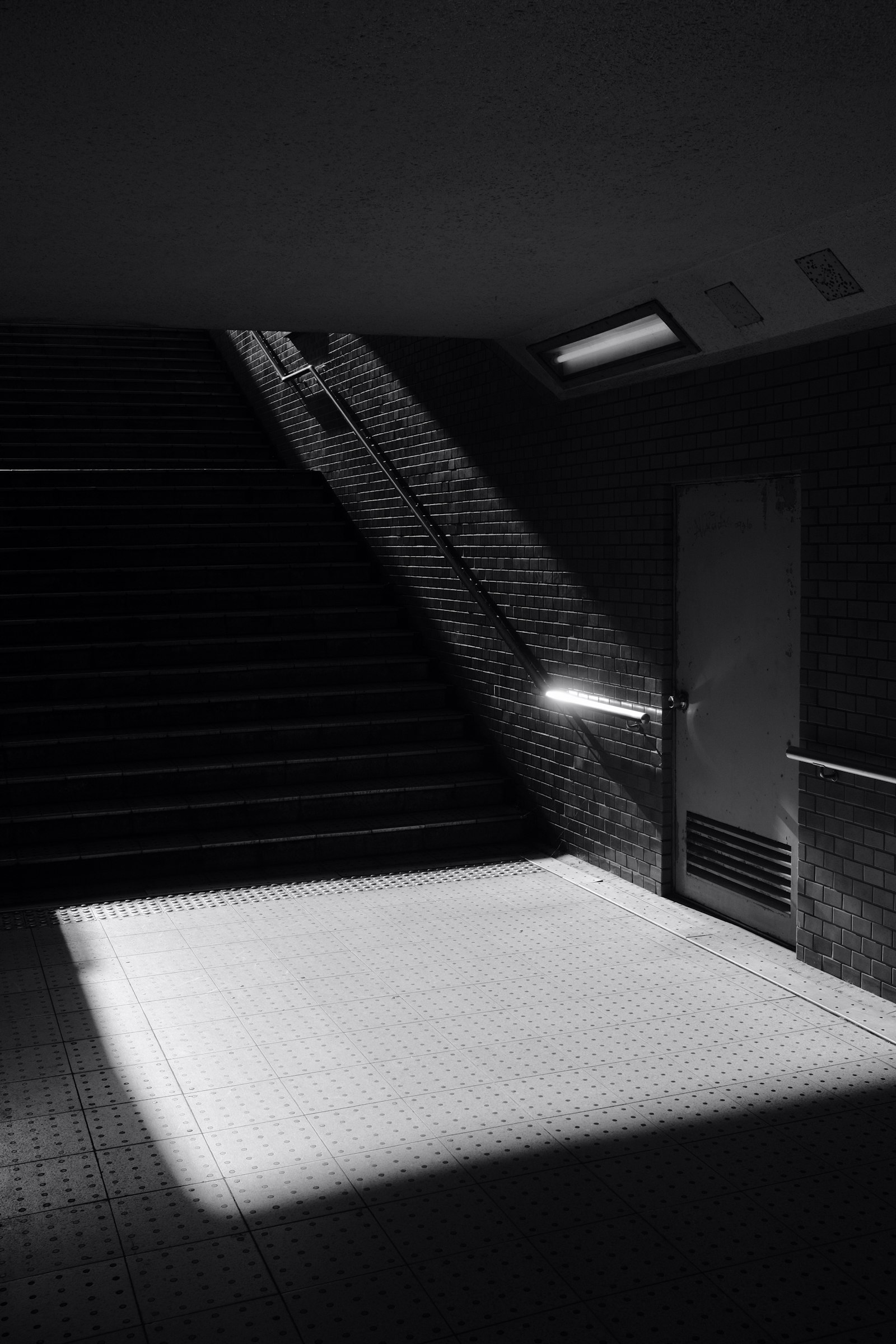 Fujifilm X100F sample photo. White tiled hallway with photography