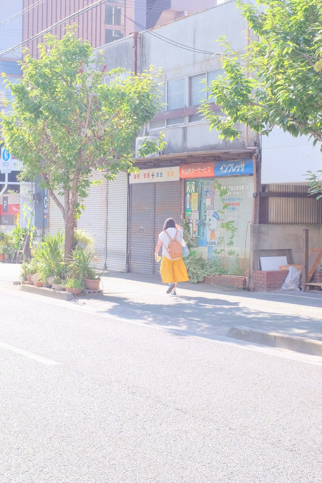 woman in yellow shirt walking on sidewalk during daytime