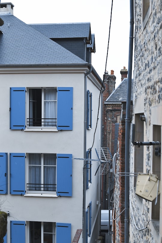 blue wooden door on white concrete building in Honfleur France