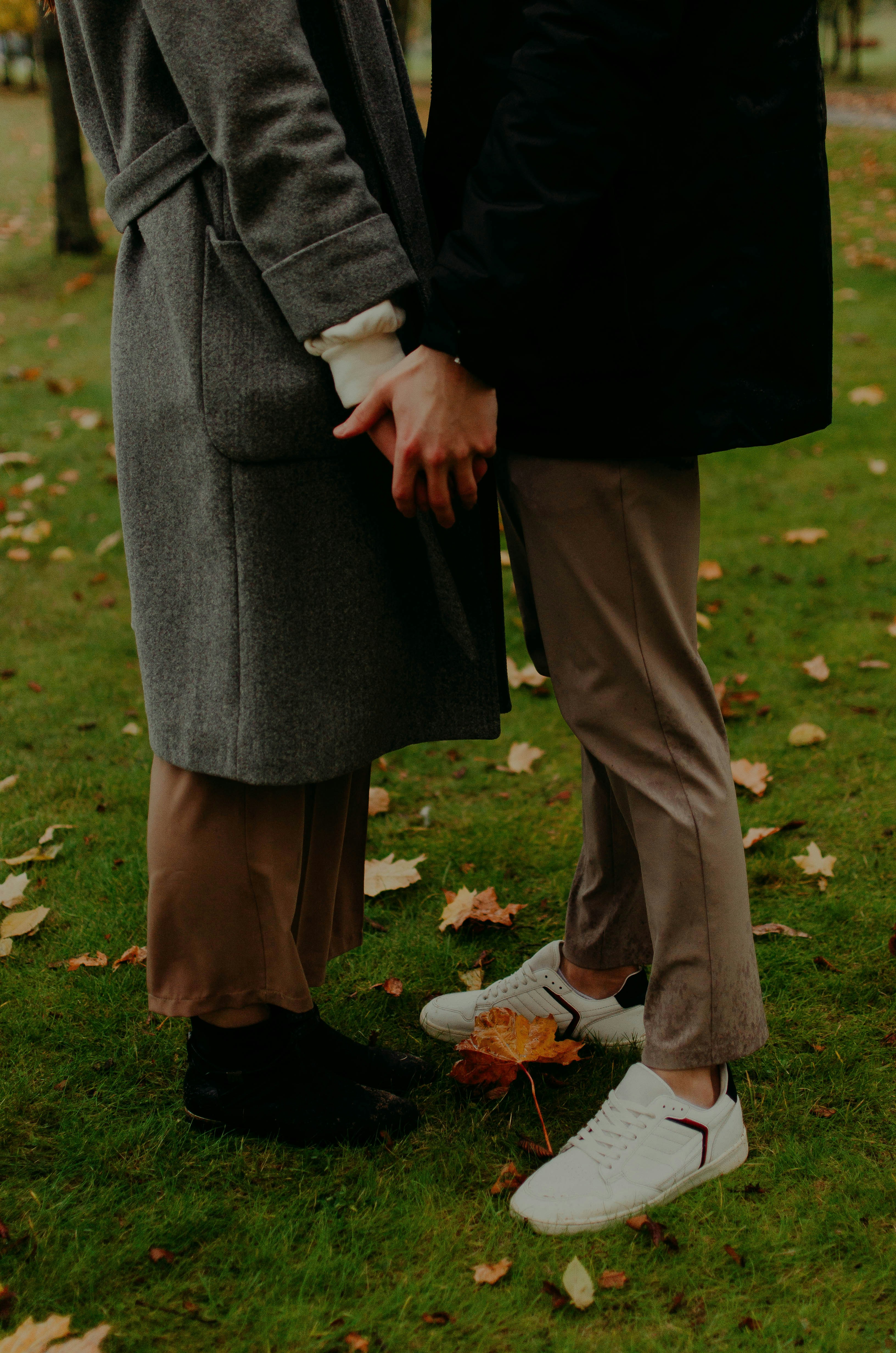 Man and woman holding hands while walking on green grass field during ...