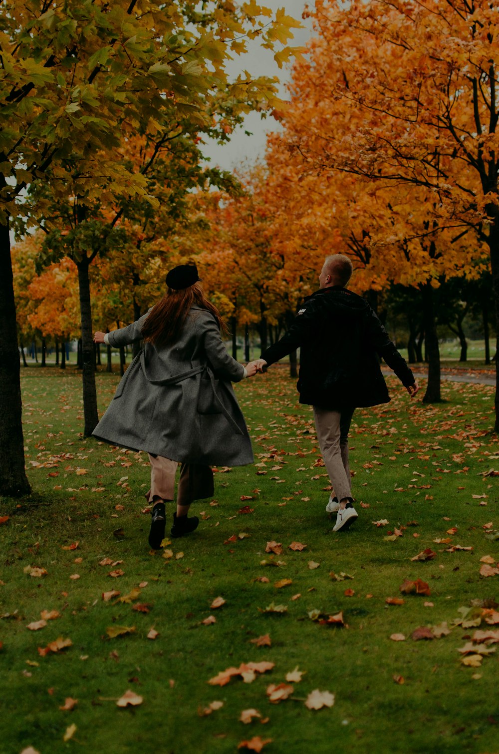 man and woman walking on green grass field during daytime