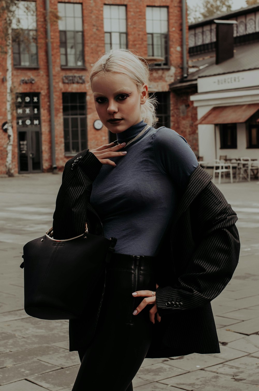 woman in black leather jacket and black leather shoulder bag