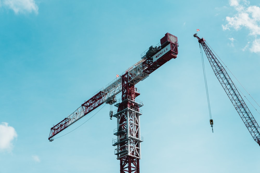 red and white crane under blue sky during daytime