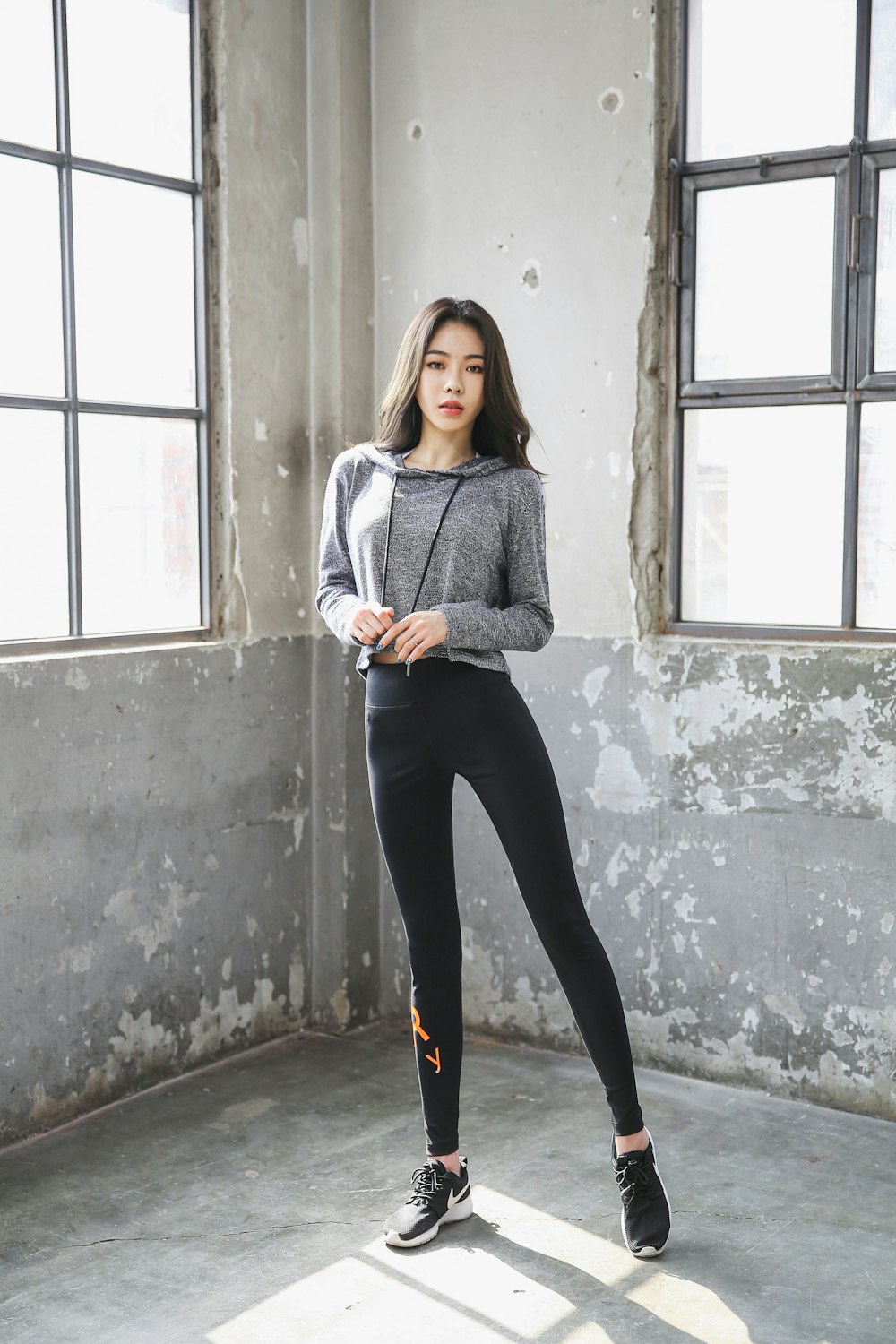 Woman in gray sweater and black pants standing beside window during daytime  photo – Free Grey Image on Unsplash