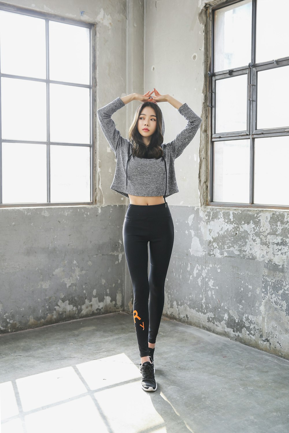 woman in black long sleeve shirt and black pants standing on gray concrete floor