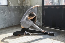 A peaceful scene of a person doing advanced stretching exercises in a bright living room.