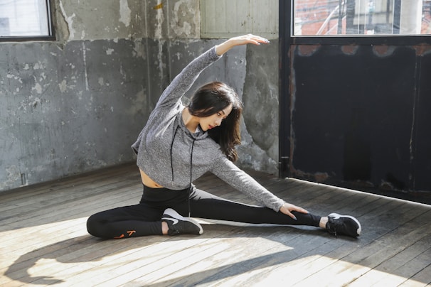 A smiling woman practicing a quick morning stretch routine in a cozy living room.