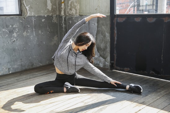 A warm, inviting photo of a person gently stretching their back in a cozy home setting.