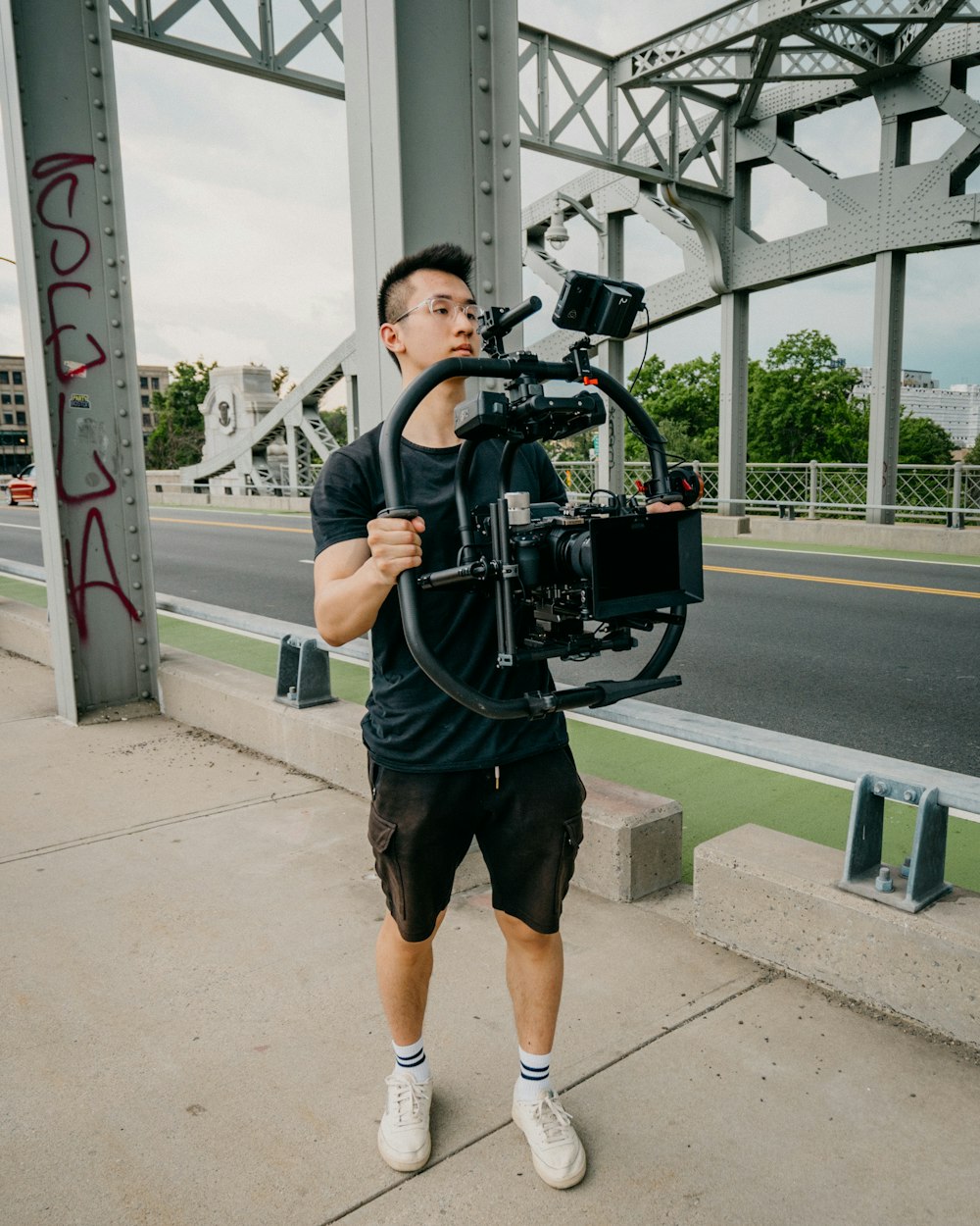 man in black and white stripe shirt holding black dslr camera