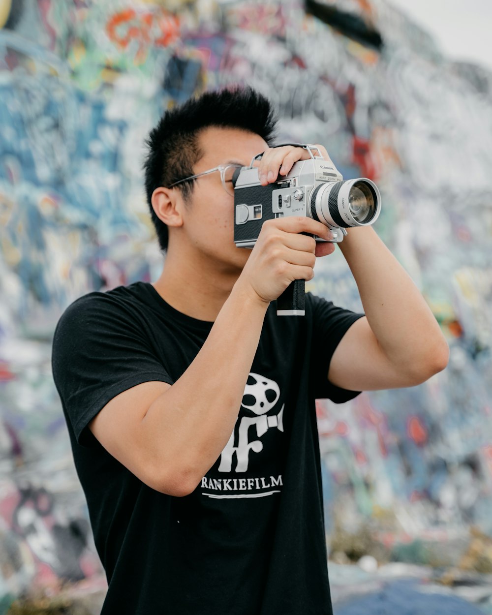 man in black crew neck t-shirt holding black and silver dslr camera