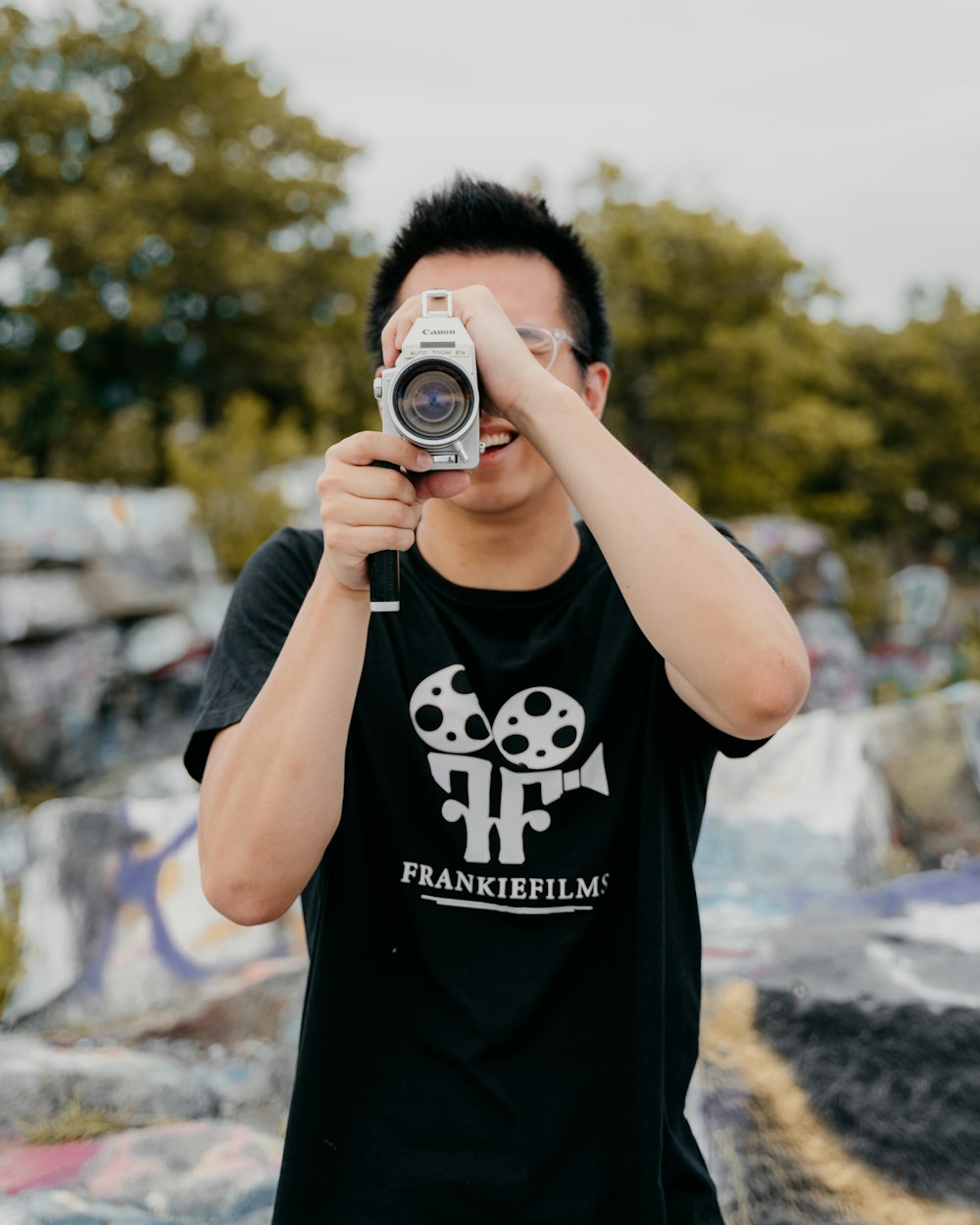 man in black crew neck t-shirt holding black and silver camera