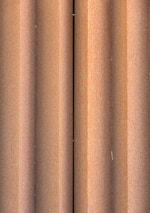 Close-up of corrugated metal sheets stacked near railway coaches.