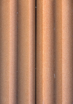 Close-up of corrugated metal sheets stacked near railway coaches.