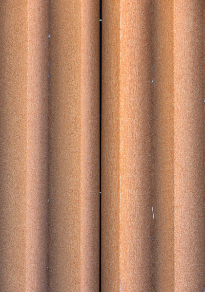 Close-up of stacked iron sheets with industrial factory background.