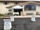 A church entrance with an outdoor setup featuring a canopy tent over a table and a wooden podium. The area is decorated with white chairs adorned with light blue ribbons, facing the podium. There's a large stained-glass window on the building façade and several benches lined up beneath it.
