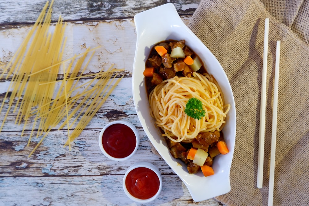 pasta with sliced vegetables on white ceramic plate