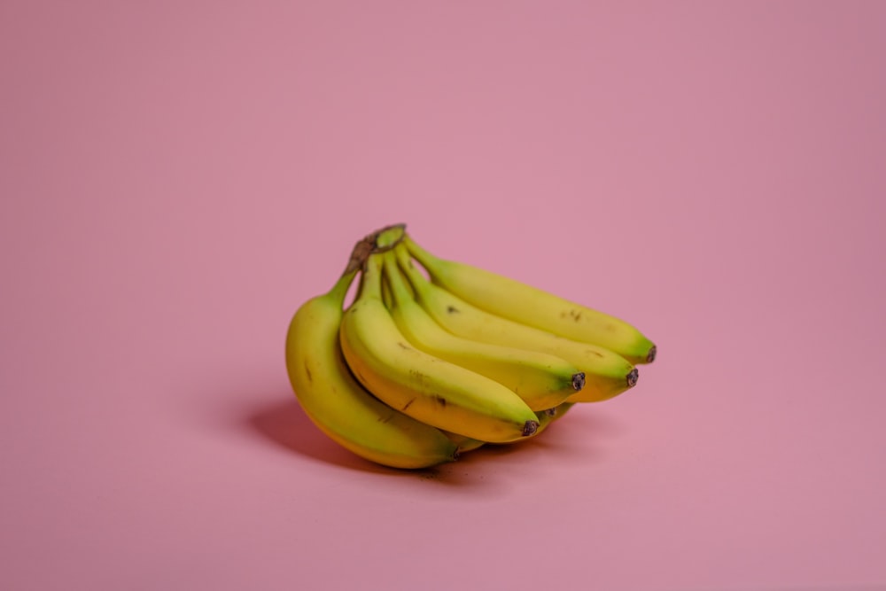 yellow banana fruit on pink surface