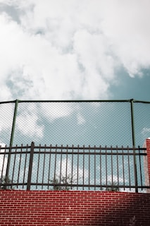 A close-up of a sturdy vinyl fence with a clear blue sky in the background.