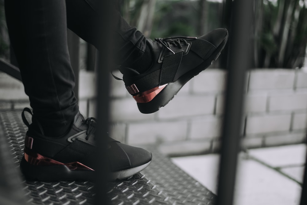person wearing black and red nike sneakers