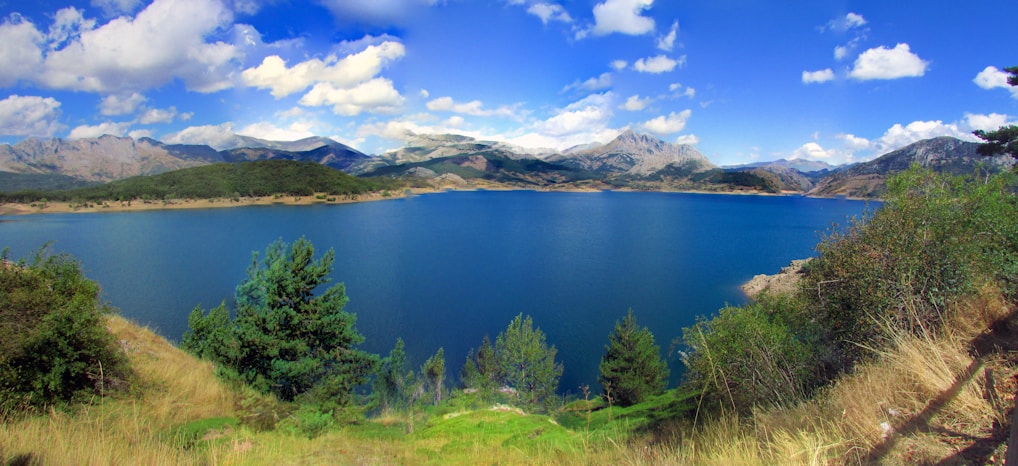 A serene lake surrounded by lush green mountains.
