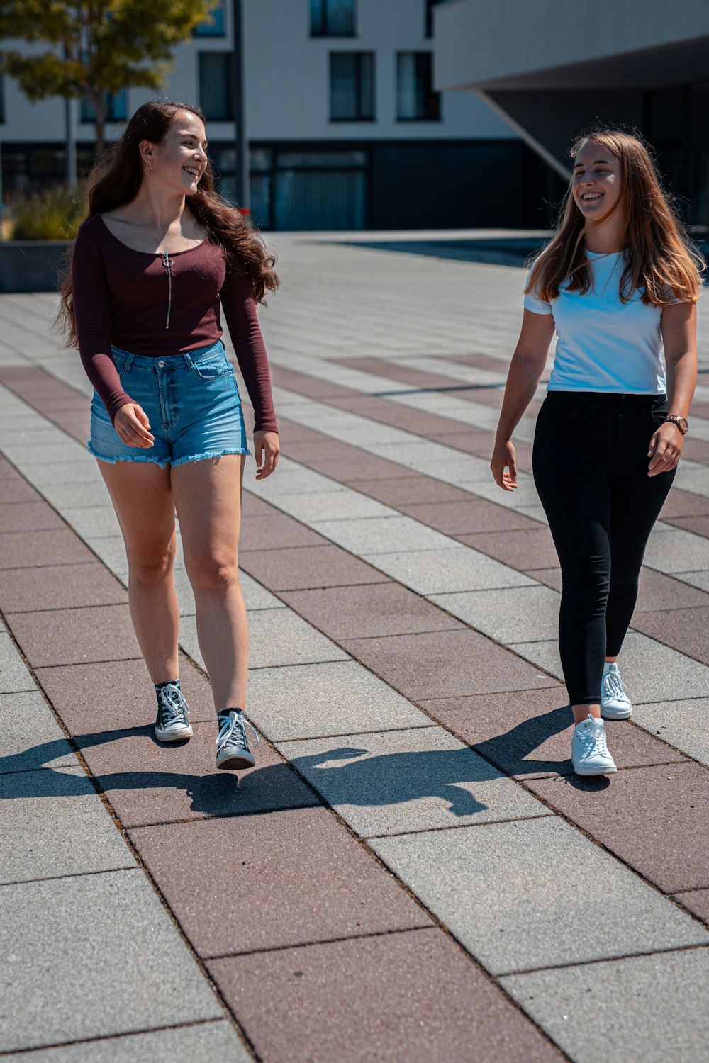 Frau in weißem Tanktop und schwarzer Leggings tagsüber auf dem Bürgersteig