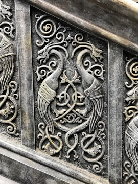 An intricate Celtic knot entwined with mythical creatures under a twilight sky.