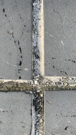 Close-up of pressure washing cleaning a stone pavement with water spray.