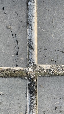 A close-up of dirt being removed from a patio.