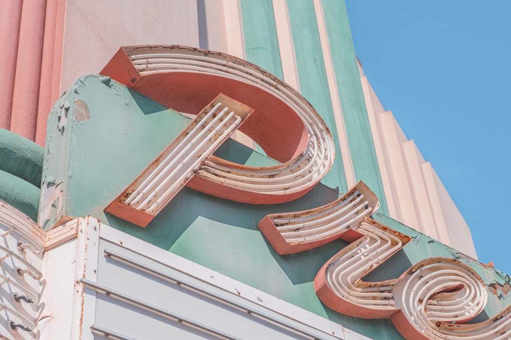 brown and white round frame on teal and pink concrete building