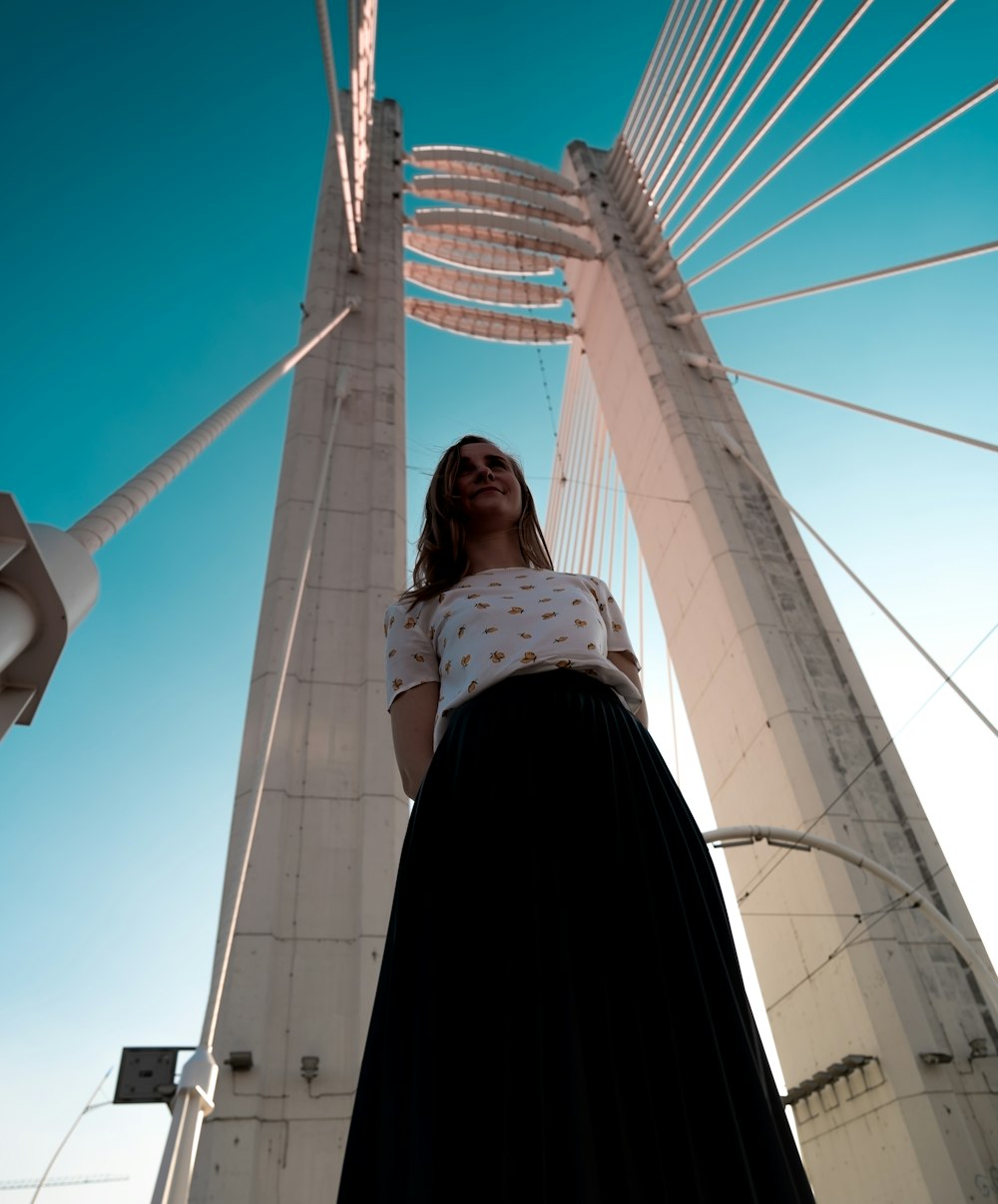 woman in black jacket standing on white bridge during daytime