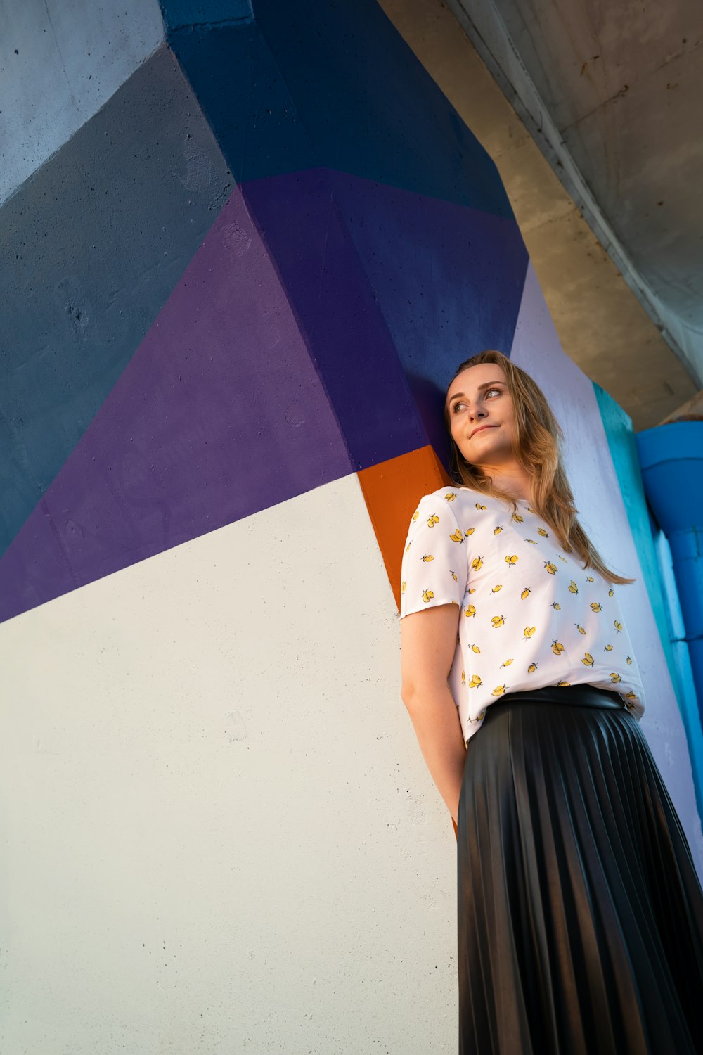 a woman standing in front of a colorful wall