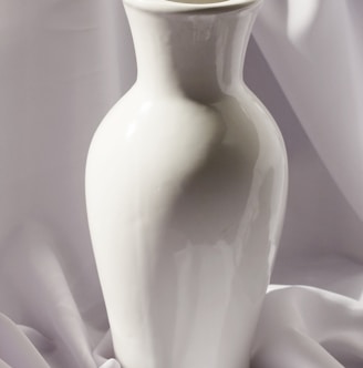 white ceramic vase on white textile