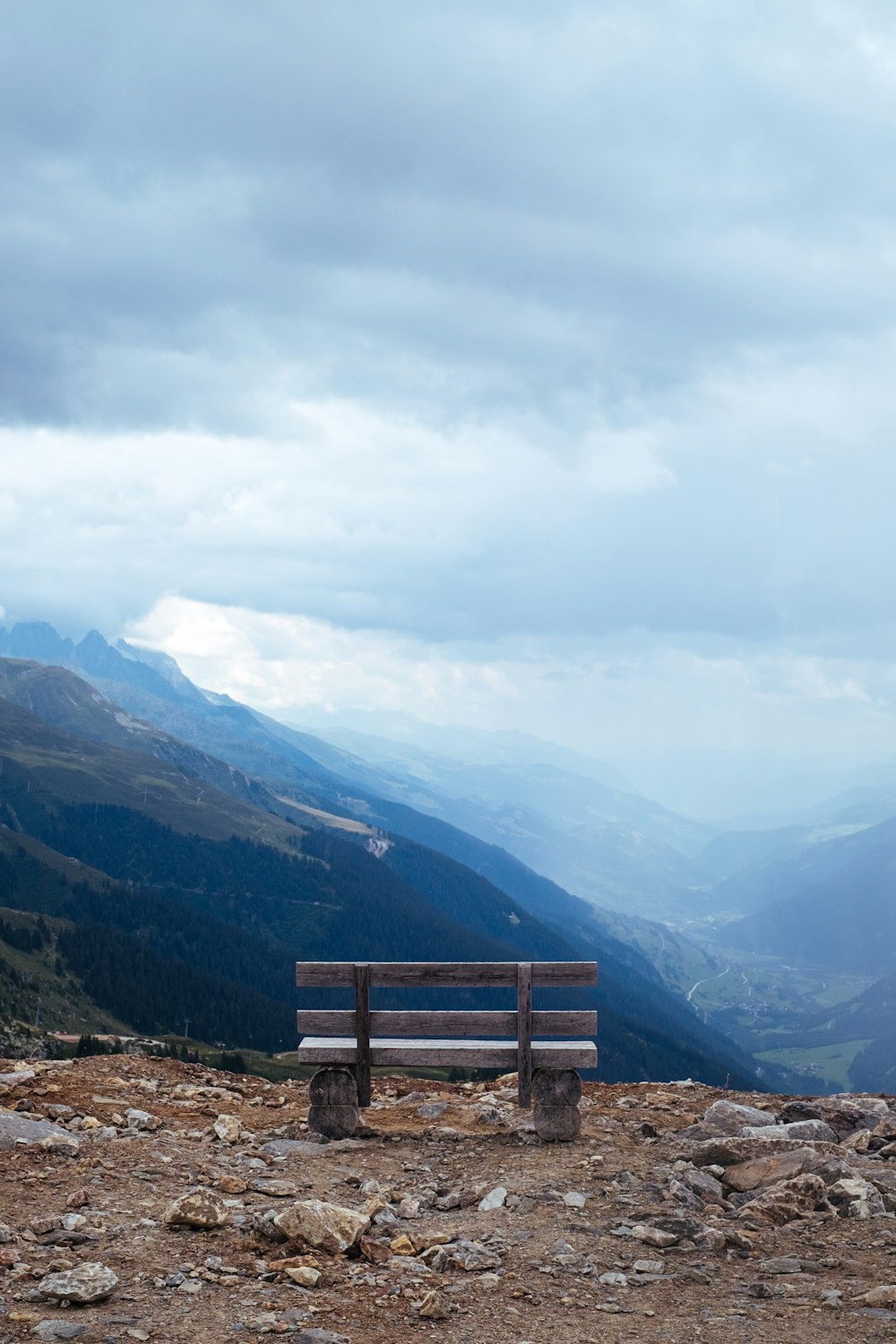brown wooden bench on top of mountain during daytime