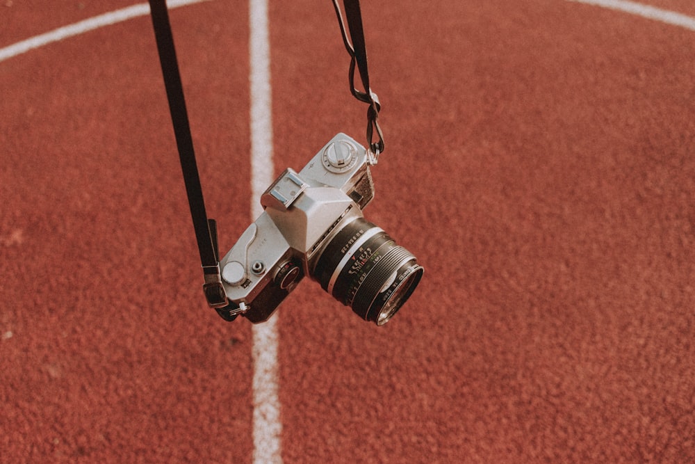 black and silver dslr camera on brown surface