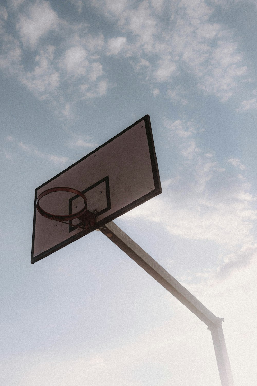 black and white basketball hoop under blue sky during daytime