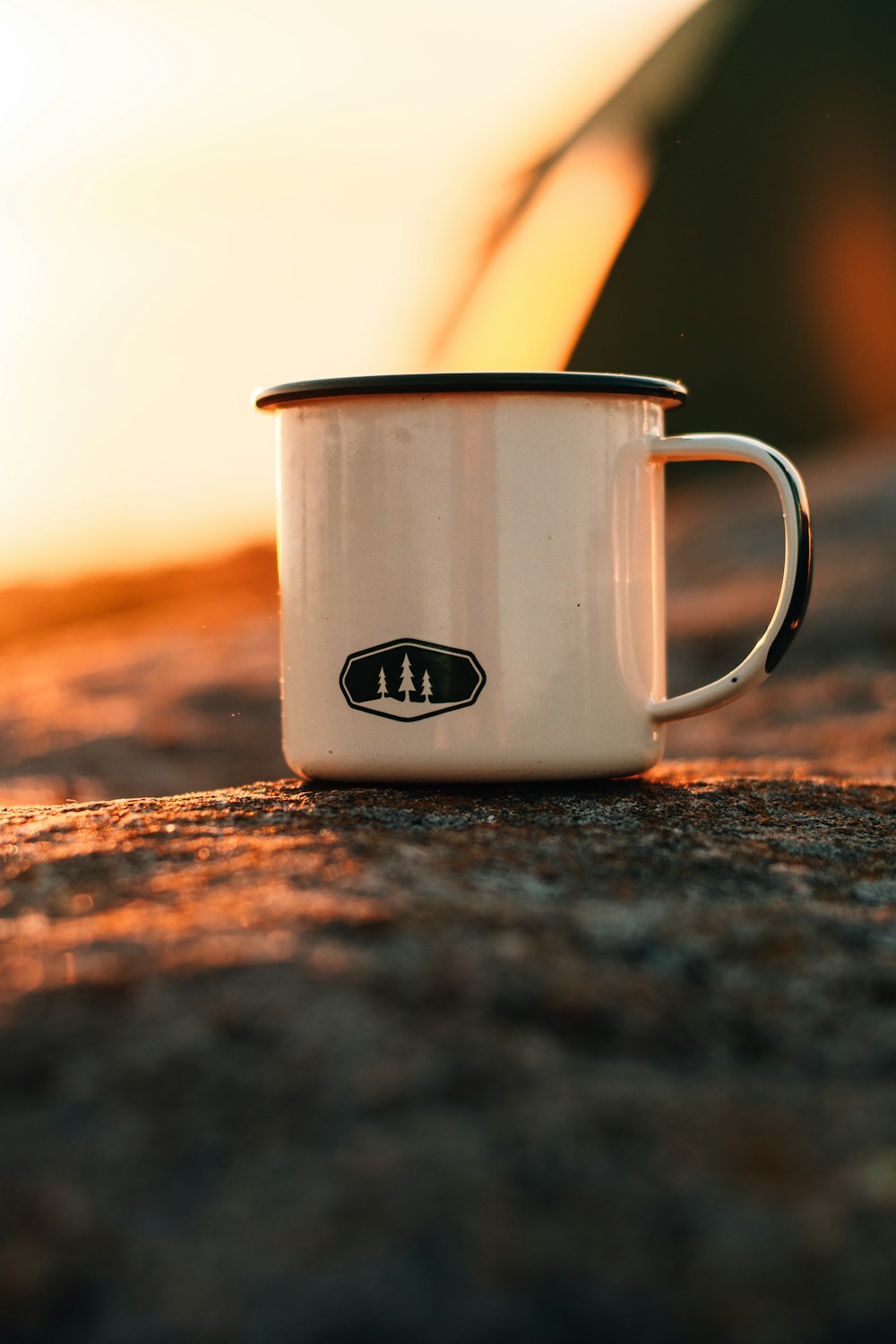 white ceramic mug on brown sand