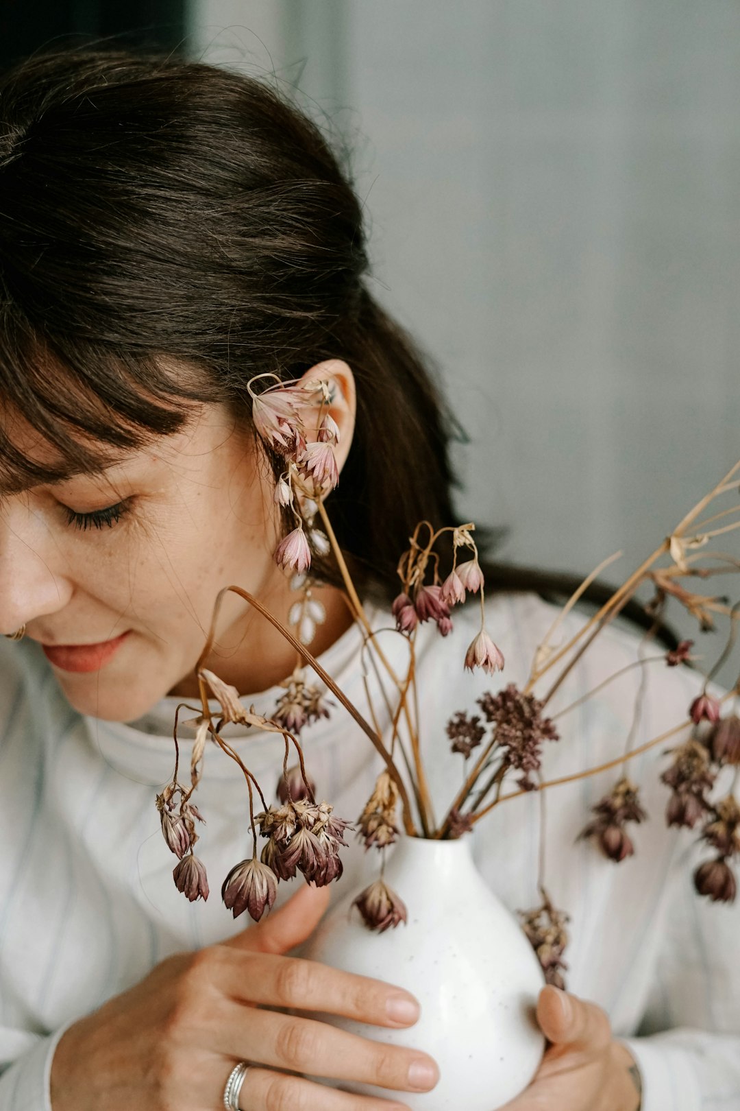 woman in white shirt with white flowers on her ear