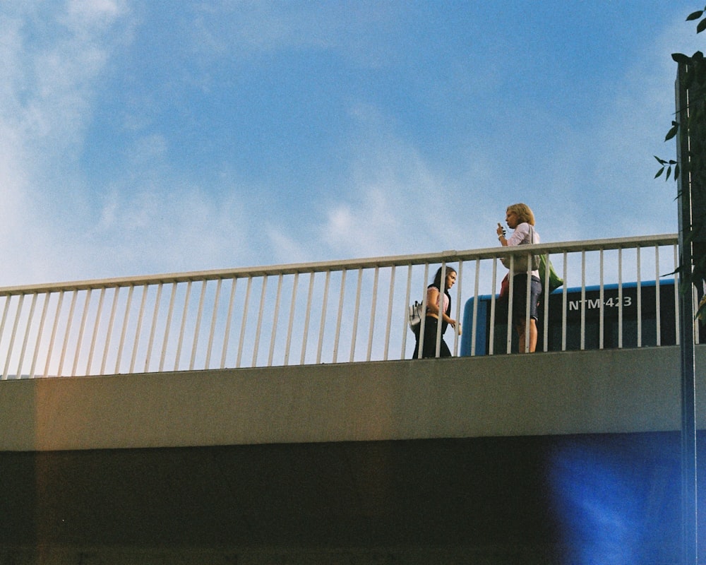 3 person standing on gray concrete building during daytime